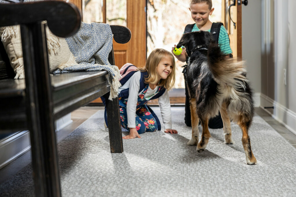 Kids plying with dog on carpet flooring | Carpet Advantage
